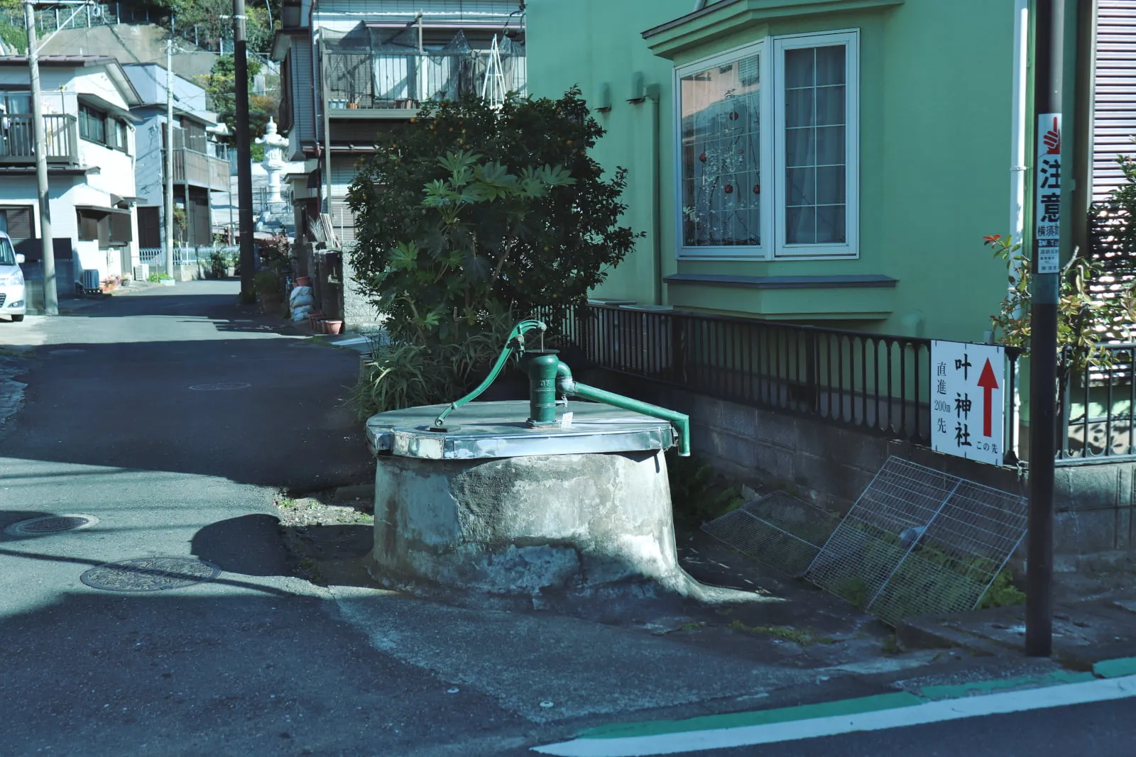 浦賀の街にぽつんと存在する、緑色のレトロな井戸の写真