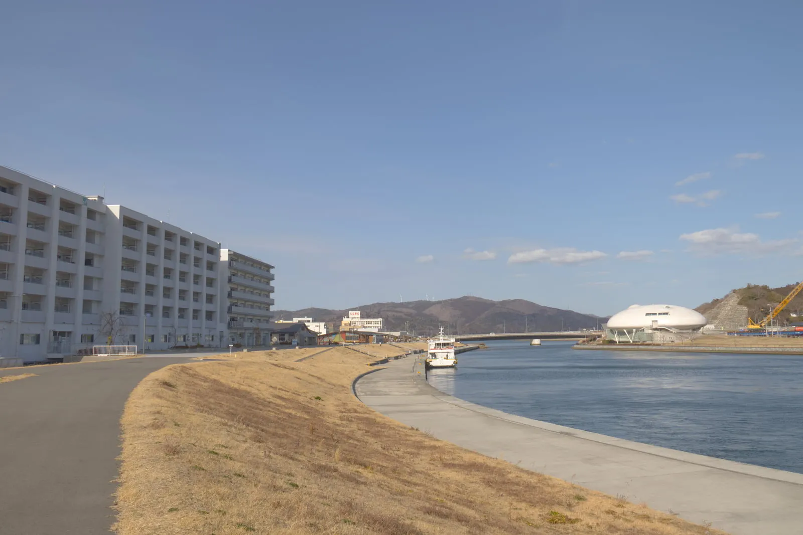 旧北上川の土手と震災復興住宅の写真