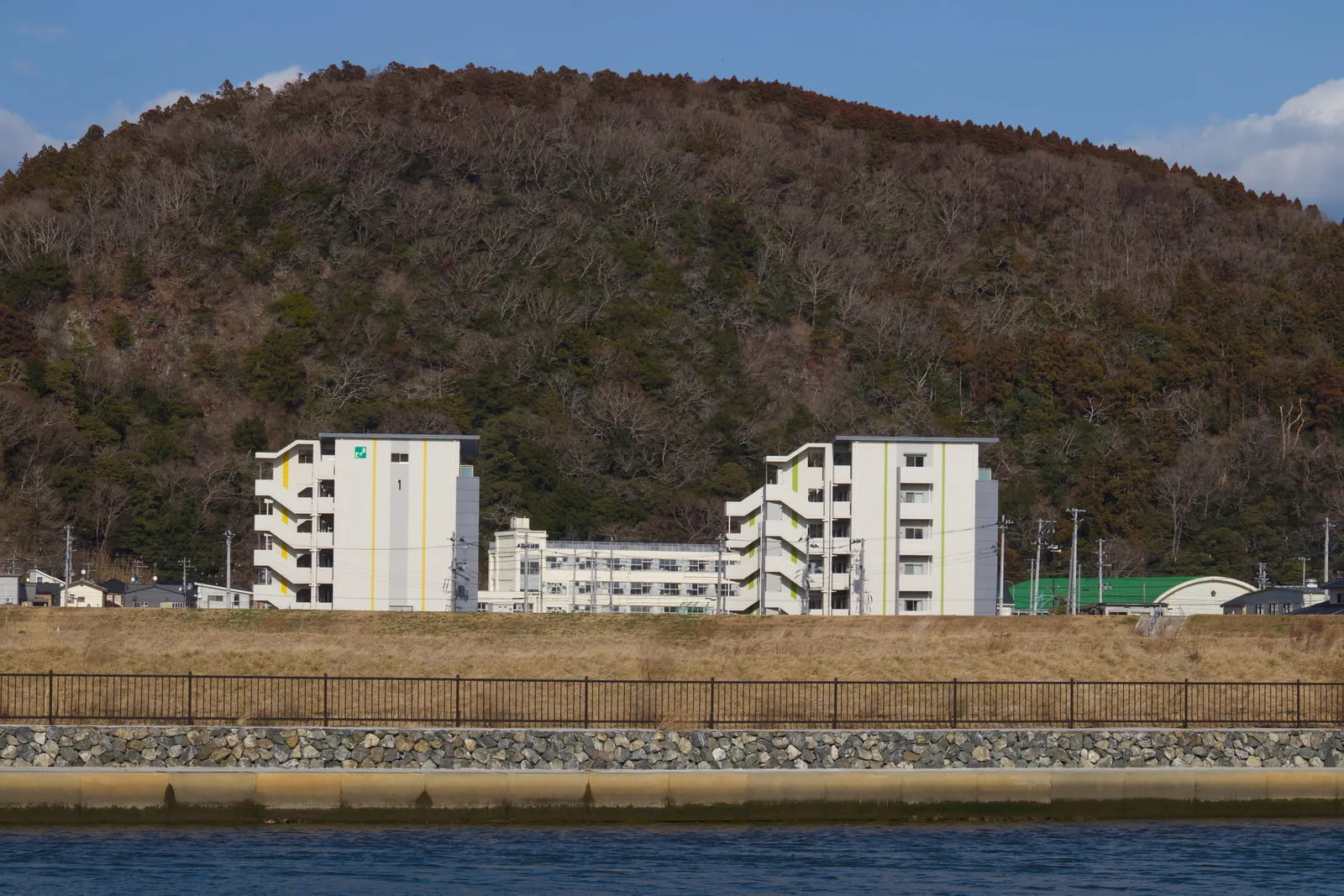 対岸の津波避難ビル標識が描かれた震災復興住宅の写真